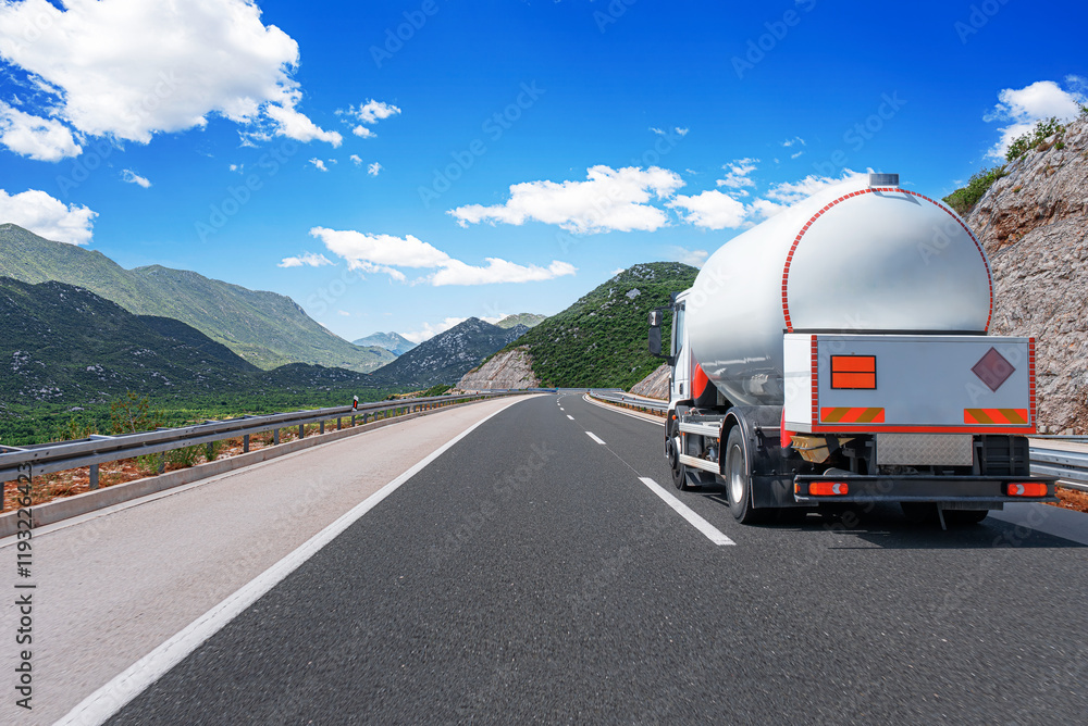 Fuel truck on a picturesque road. A silver tank truck transports fuel.