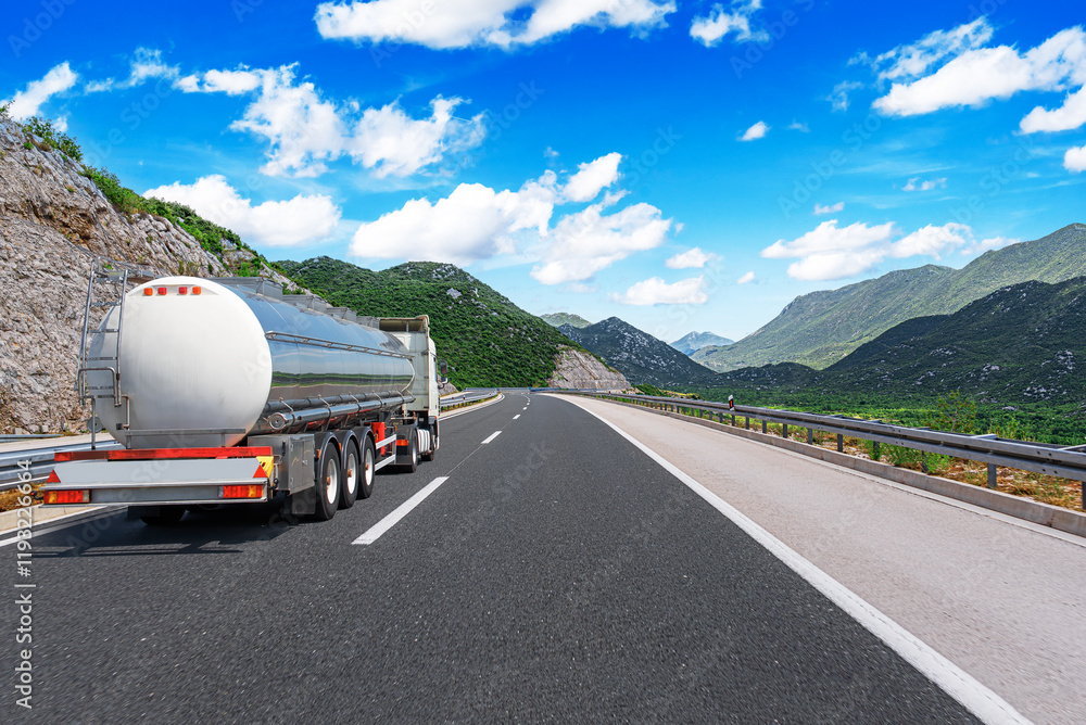 Fuel truck on a picturesque road. A silver tank truck transports fuel.