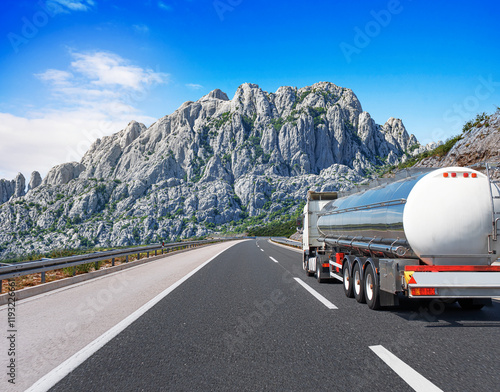 Obraz na płótnie Fuel truck on a picturesque road. A silver tank truck transports fuel. w salonie