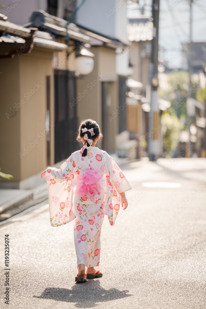 Japanese young girl wearing kimono Yukata walking in the street in Kyoto, Japan. Japanese young girl wearing kimono Yukata walking in the street in Kyoto, Japan.