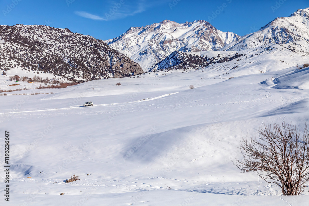 Winter landscape with mountains covered with snow under blue sky on cold sunny day Winter landscape with mountains covered with snow under blue sky on cold sunny day