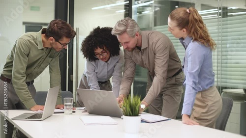Startup business team on meeting in modern bright office interior and working on laptop