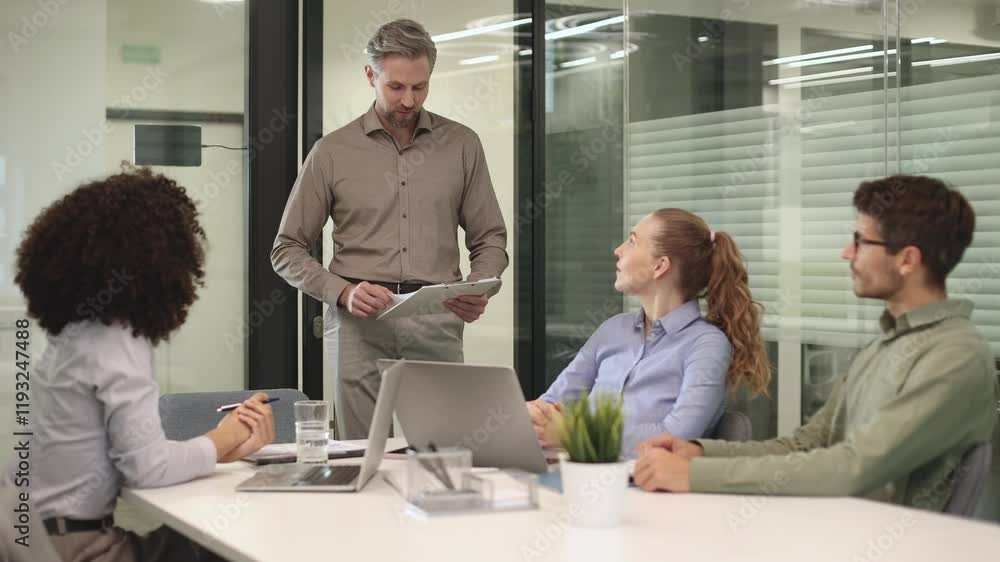 Business people discussing work together using a tablet and laptop taking notes in a modern office