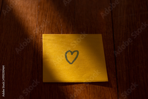 Post-it sur une table dans la lumière avec un coeur de dessiné dessus photo