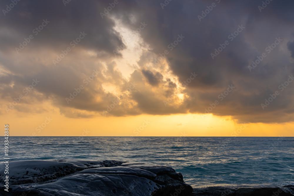 Obraz premium sunrise dramatic sky over sea horizon from rocky shore at dawn long exposure shot