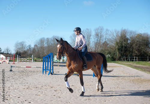 beautiful young woman riding her young mare outdoors photo