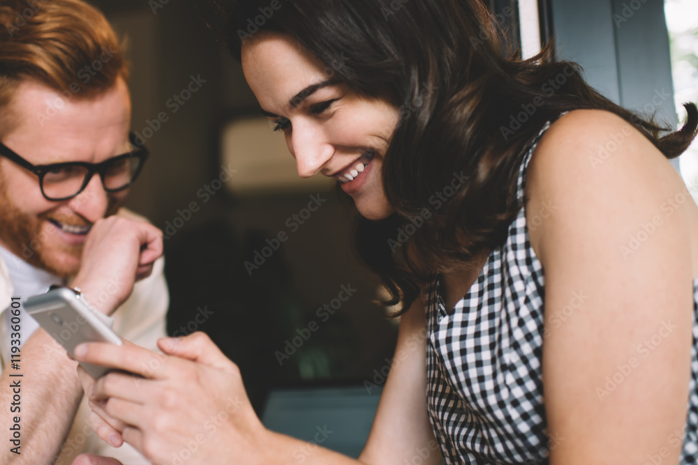 Woman using smartphone and laughing with friend Woman using smartphone and laughing with friend