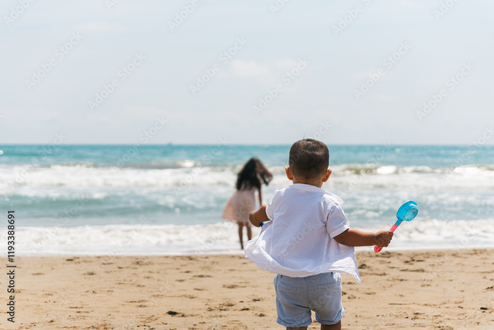 Brother and sister running and playing on the beach during summer vacation Brother and sister running and playing on the beach during summer vacation