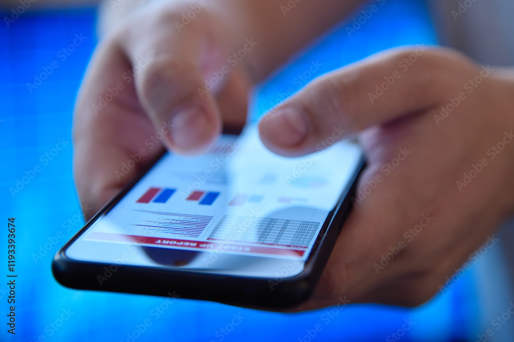 Hands using a mobile phone displaying financial charts Hands using a mobile phone displaying financial charts