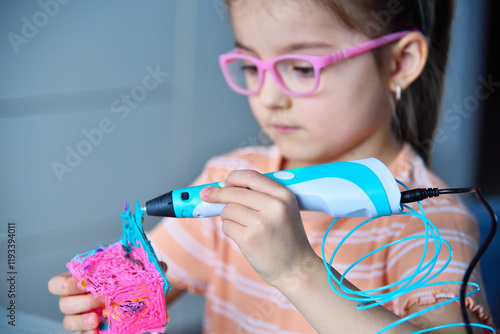 Child plays with a 3D pen. The girl creates a 3D toy.