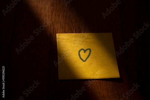 Post-it sur une table dans la lumière avec un coeur de dessiné dessus photo