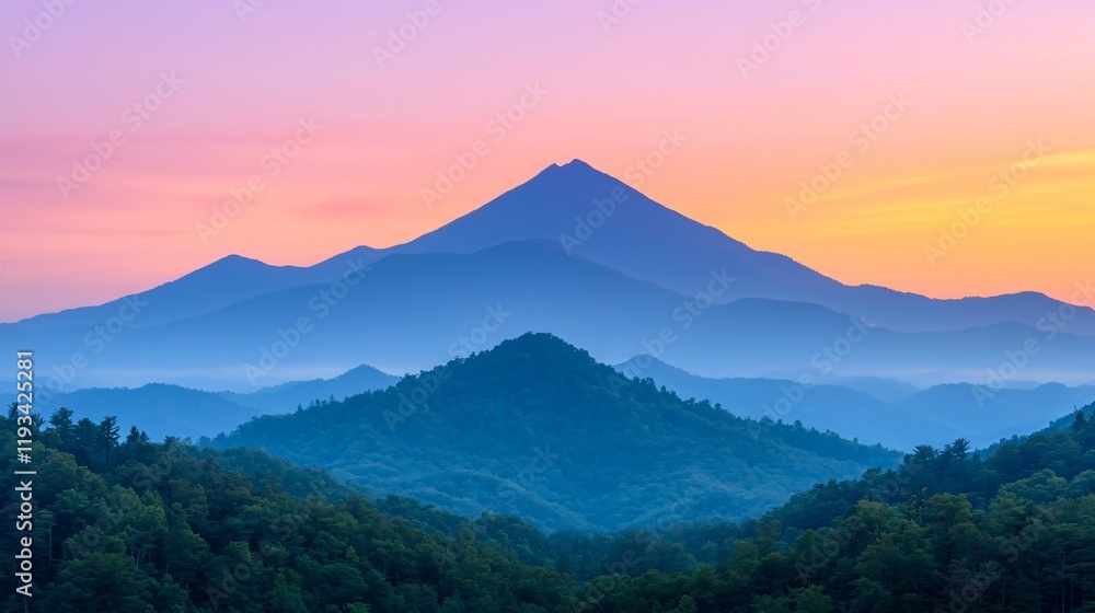 Serene sunrise over layered mountains, creating a hazy, colorful landscape.
