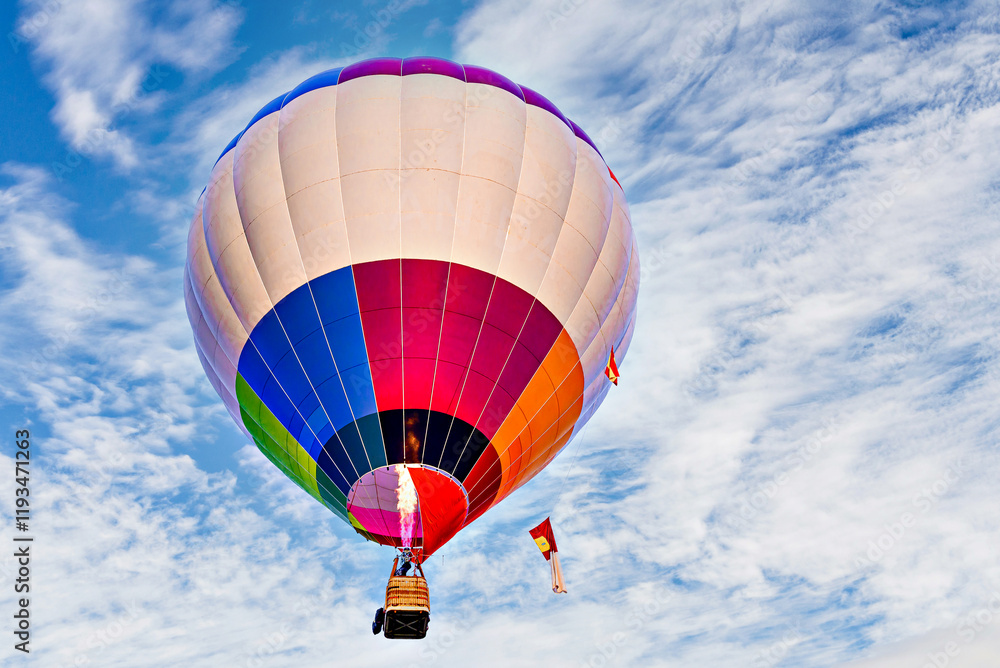 Fototapeta premium Colorful hot air balloon flying over blue sky with white clouds