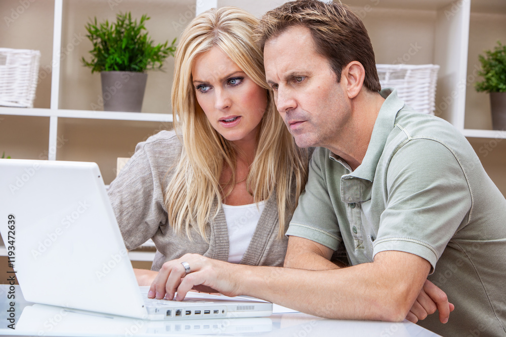 Worried Man and Woman Couple Using a Laptop Computer at Home, internet and cost of living concept Worried Man and Woman Couple Using a Laptop Computer at Home, internet and cost of living concept