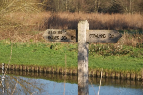 Footpath sign beside the River Wey in Surrey. Indicating distances to Guildford, Godalming & Thames Lock photo