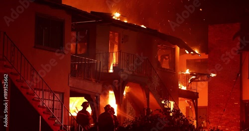 Altadena, California, USA - January 8, 2025: Firefighters work to put out a blaze at an apartment complex caused by the Eaton Fire.
