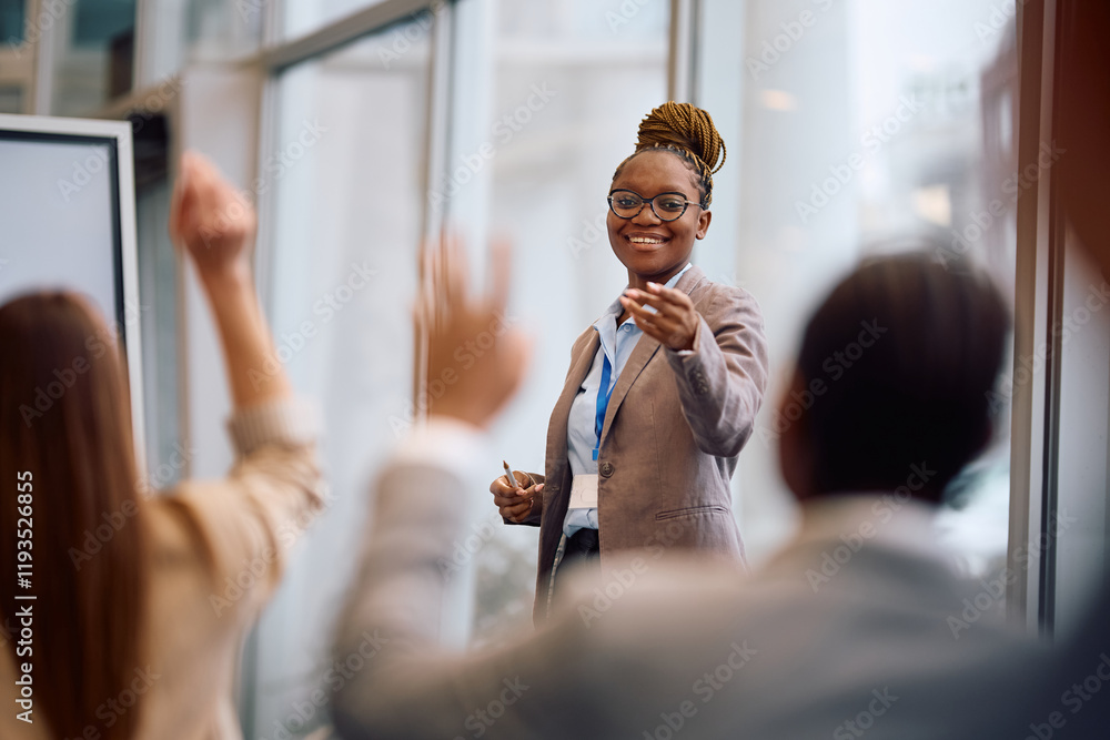 Fototapeta premium Happy black business seminar speaker pointing at attendee who wants to ask question in conference room.