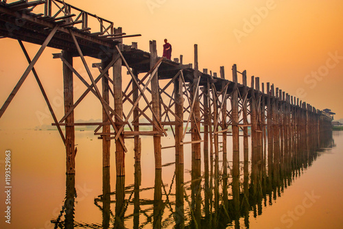 Silhouette of U Bein bridge at sunset in Myanmar.  and reflecting bridge the water photo