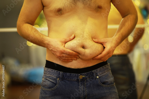 Close-Up of Man Grabbing Belly Fat, Demonstrating Weight Gain and Body Image Concerns
