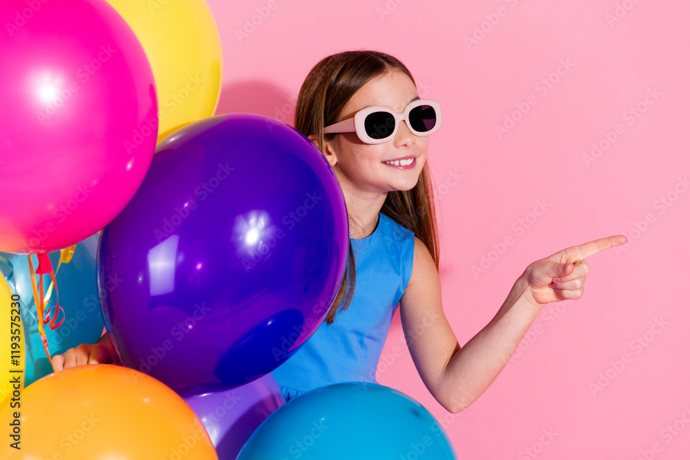 Obraz premium Young girl in bright colors having fun against a pink background with balloons