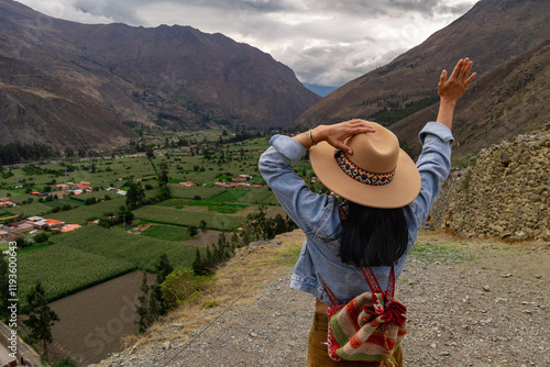 Latin tourist viewing the agricultural areas from the fortress of Ollantaytambo photo