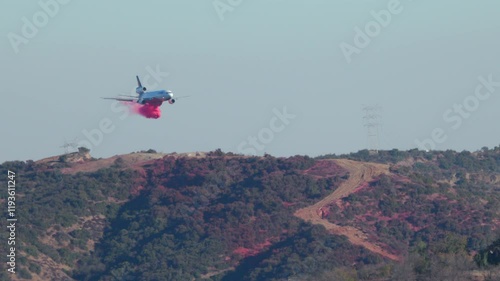 Wallpaper Mural In Los Angeles, a vital firefighting plane is conducting aerial operations above rugged mountains to combat severe wildfires threatening nearby homes and communities with destruction Torontodigital.ca