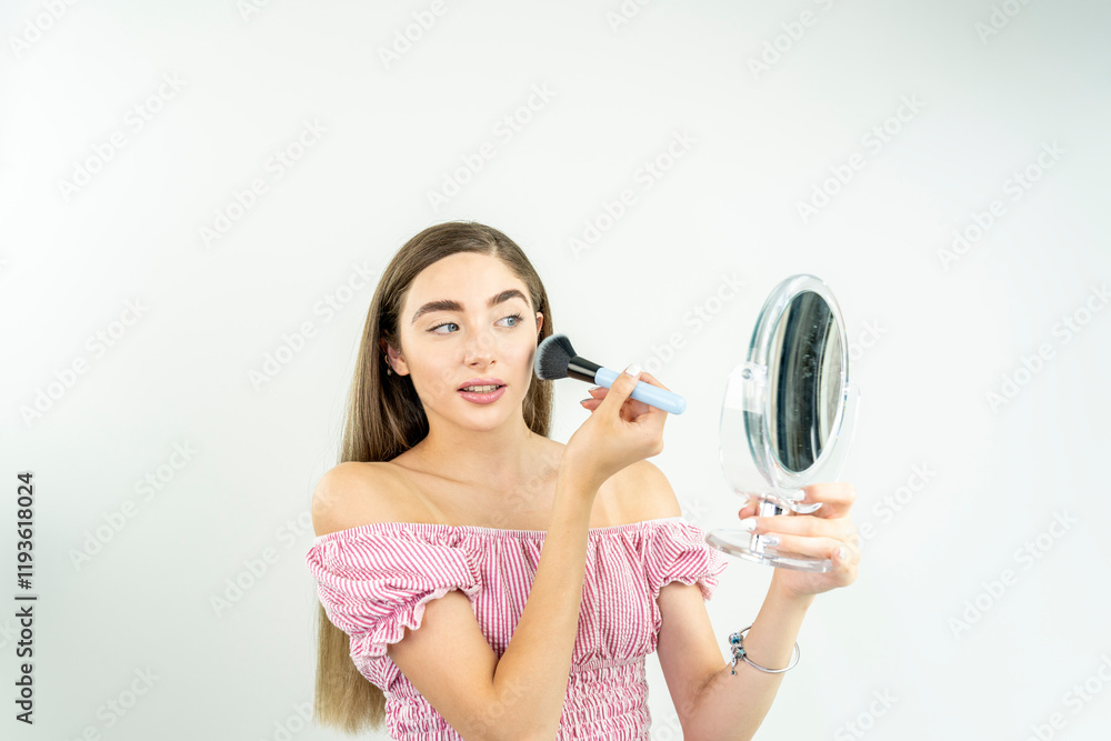 A woman is applying makeup in front of a mirror A woman is applying makeup in front of a mirror
