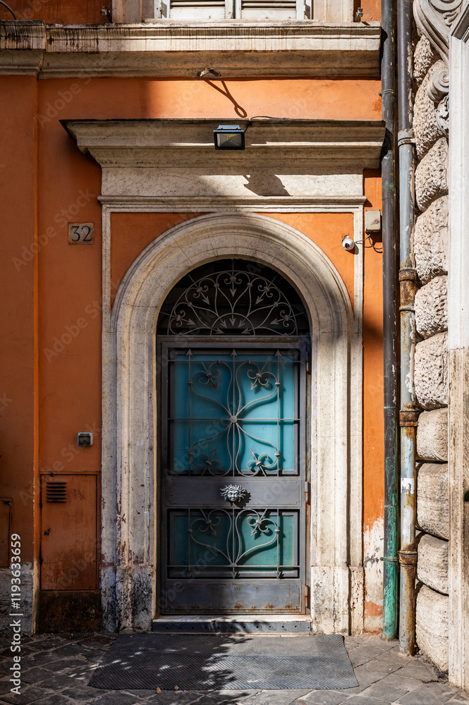 Fototapeta premium Decorative arched blue door and an orange building