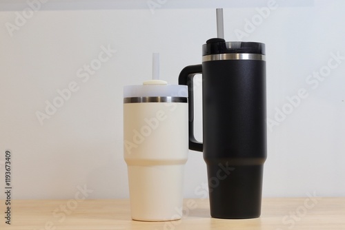 Two Insulated Tumblers, One Black and One Beige, with Reusable Straws, Lids, and Stainless Steel Accents. Reusable, Eco-friendly, and Portable
