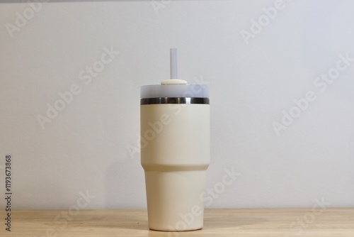 Isolated Cream-Colored Insulated Tumbler with Straw Against White Background. Modern and Eco-friendly Reusable Beverage Cup
