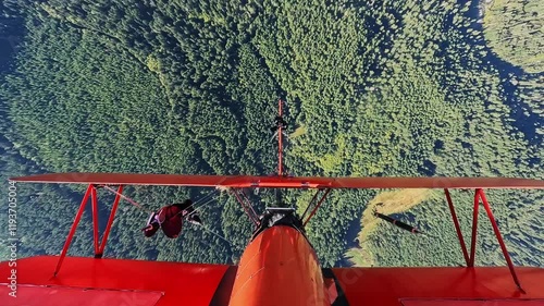 Pilot Performing Loop with Person on Airplane Wing in Flight