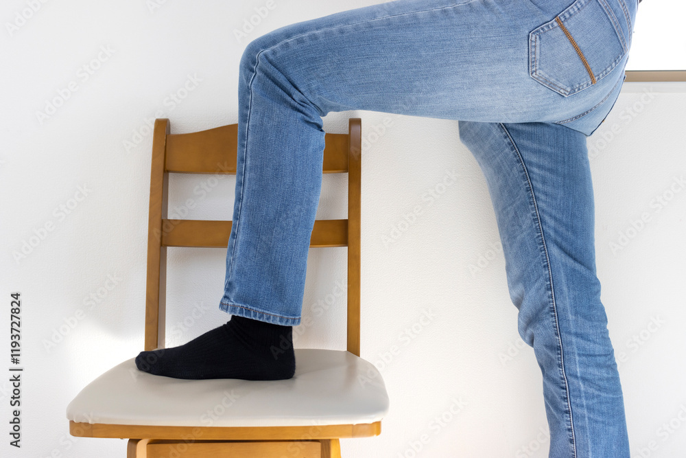 椅子に登ろうとしている男性の脚(日本人、30代、顔無し)