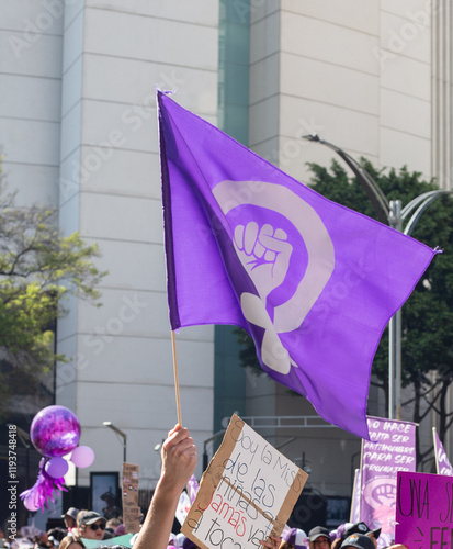 Fotografie Bandera purpura con puño en alto feminista, en marcha del día internacional de l