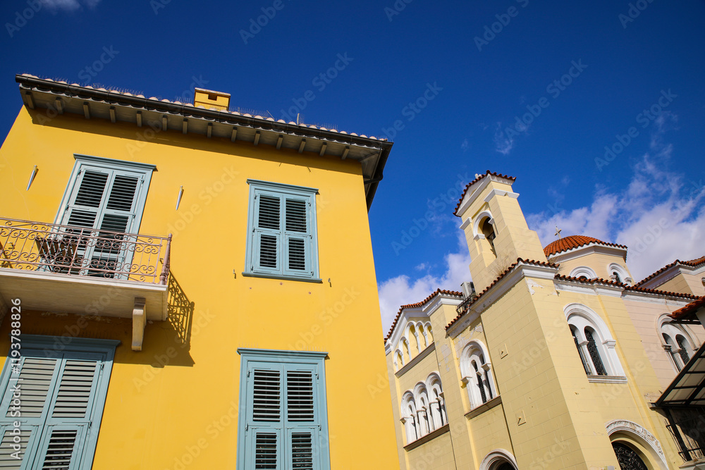 Athens, Greece. Yellow Mediterranean building with balconies and blue shutters and a red Greek church and dome Athens, Greece. Yellow Mediterranean building with balconies and blue shutters and a red Greek church and dome