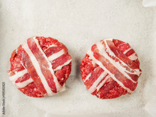 Canvas Print Premium beef burger wrapped in bacon or rasher on cooking paper in a cooking tray