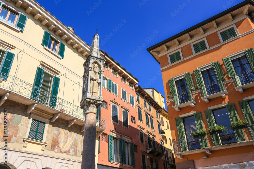 Obraz premium Verona, Italy. Colorful painted buildings in old town with shutters and a statue of a saint