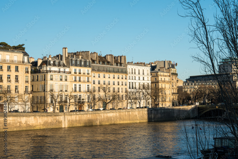 Fototapeta premium Beautiful riverside view of historic Parisian architecture during sunset