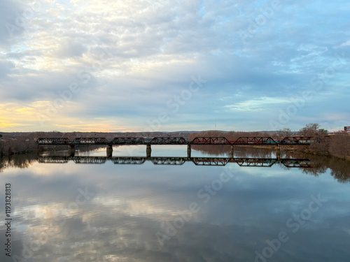 Bridge in Springfield MAssachusetts Reflecting on Calm Water at Sunset in a Serene Riverside Setting photo