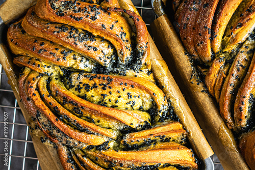 Close-up of Glazed Matcha Black Sesame Babka: Above loaf of twisted green tea and sesame dessert bread in parchment lined loaf pan photo