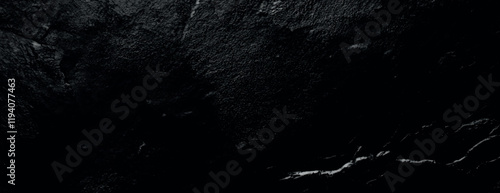 Dark black background with a textured, rough surface. The black background adds a dramatic, moody feel with subtle variations in texture. Textured stone background vector. Black background.