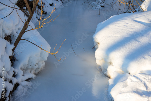 Bild auf Leinwand A stream bound with white ice on a frosty winter day