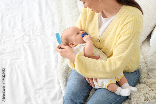 Mother combing her little b...