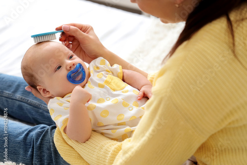Mother brushing her little ...