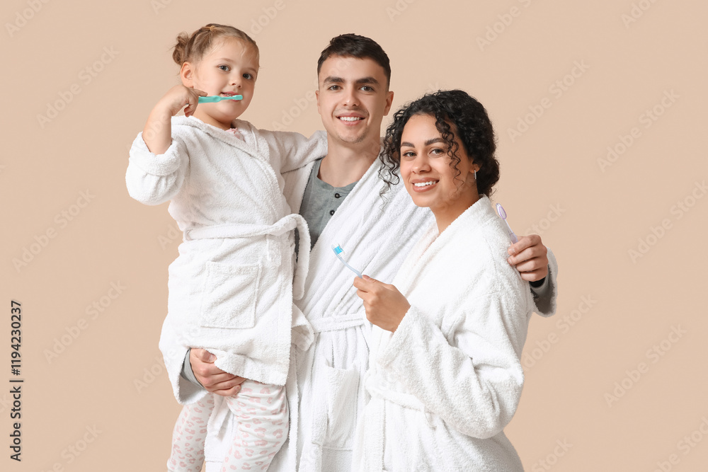 Little girl and her parents in bathrobes with toothbrushes on beige background Little girl and her parents in bathrobes with toothbrushes on beige background