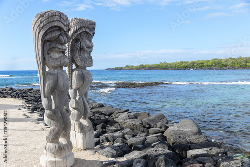 Wooden carved statues of Hawaiian gods, Protectors ki'i, at the shore of Pacific ocean. Puʻuhonua o Hōnaunau national historical park, Hawaii, the USA. photo