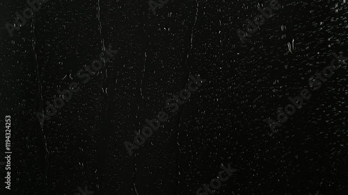 Closeup water rainfall, rain drops falling on window glass over black background