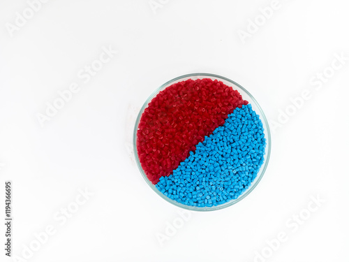 Colorful masterbatch plastic granules in transparent glass cup, polymer carrying pigment poured in white background, suitable for product catalog design of plastic manufacturing industry company profi photo