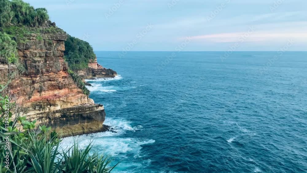 Massive waves crasing against cliffs on gunung kidul beach, Yogyakarta. Captures the raw power of the ocean and dramatic coastal scenery. Massive waves crasing against cliffs on gunung kidul beach, Yogyakarta. Captures the raw power of the ocean and dramatic coastal scenery.