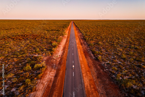 Man standing in the middle of the road in the outback, aerial view, Australia photo