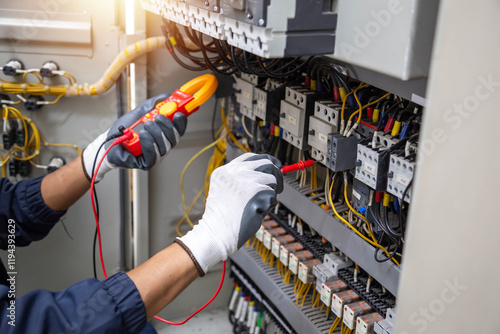 Checking the electrical system, an electrician is using an electric meter to check the electrical system at a control cabinet. for safety